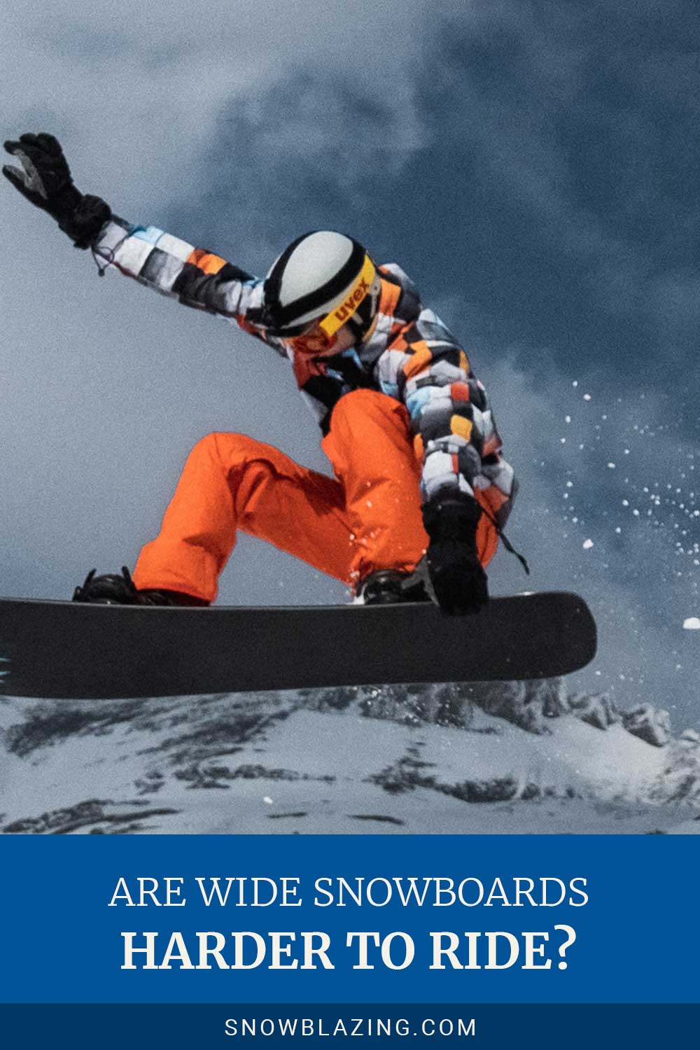 Person wearing orange pants doing aerial with a snowboard - Are Wide Snowboards Harder To Ride?