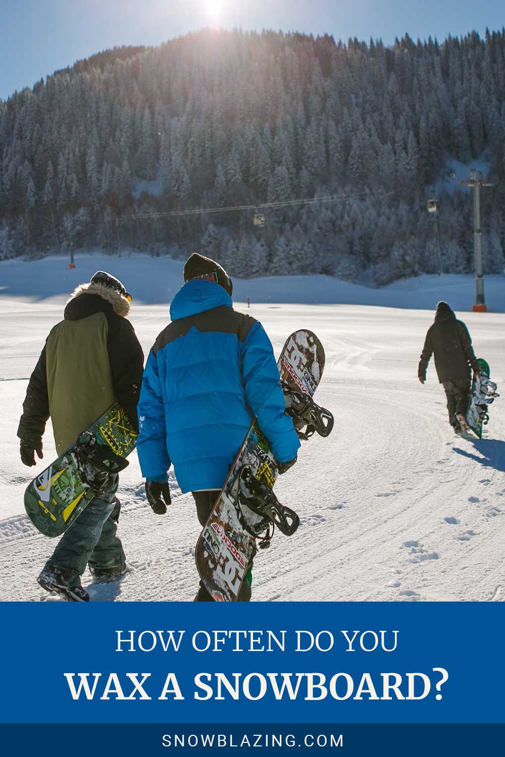 People walking on snow with snowboards in hand - How Often Do You Wax A Snowboard?
